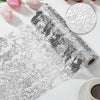 A roll of silver and black sequin glitter table runner material next to a circular swatch.