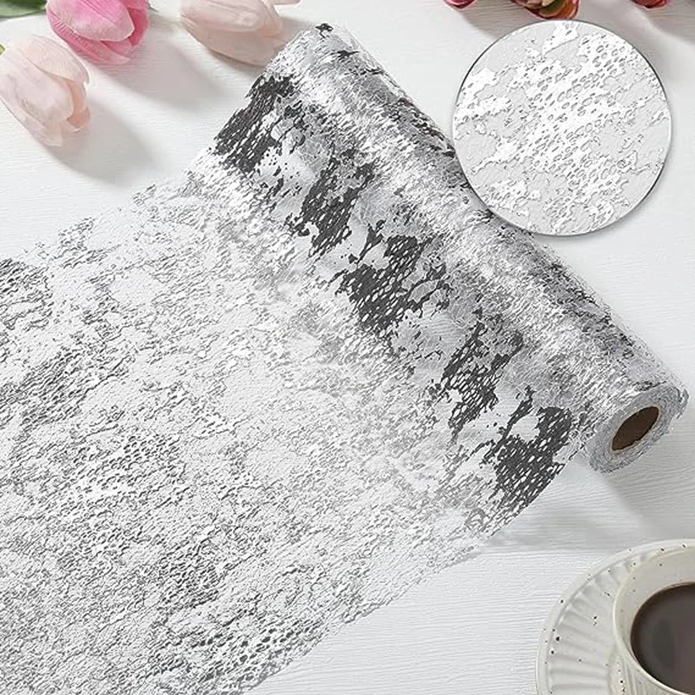 A roll of silver and black sequin glitter table runner material next to a circular swatch.