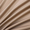 Close-up of beige luxury bamboo flat sheets draped in soft, flowing folds.