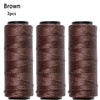 Three spools of brown sewing thread used for hair extensions
