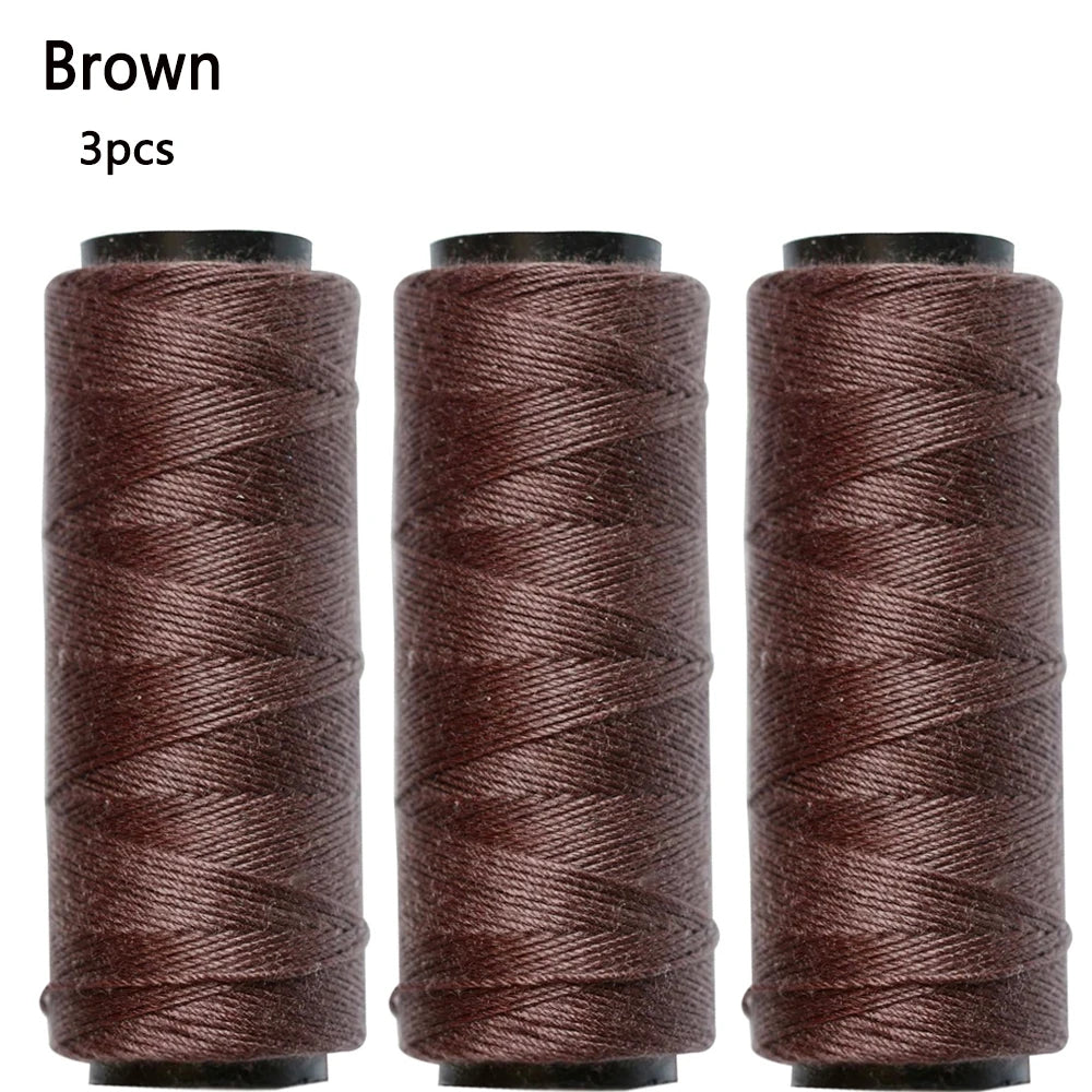 Three spools of brown sewing thread used for hair extensions