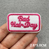Pink embroidered patch with the text Bad Hair Day on a white background