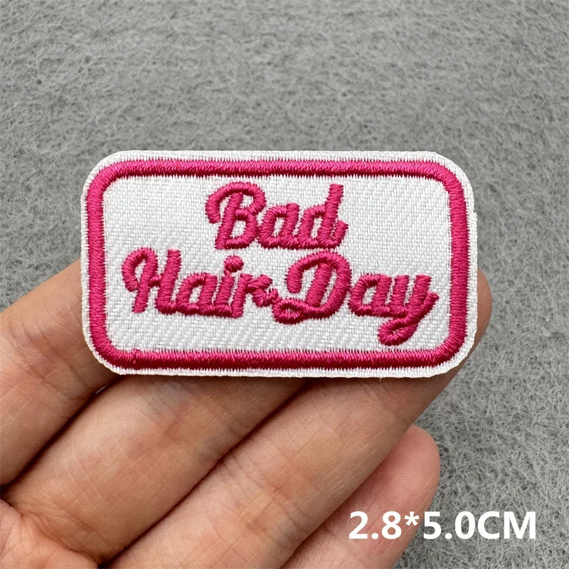 Pink embroidered patch with the text Bad Hair Day on a white background
