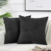 A set of black retro corduroy patchwork pillow covers displayed on a white sofa.