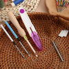 A precision punch needle kit featuring a pink and white tool with a wooden handle resting on a woven basket.