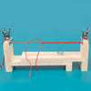 A wooden braiding frame with pliers and a red cord is displayed on a blue surface.