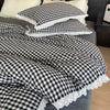 A black and white checkered plaid duvet cover and pillowcase set with white lace trim.