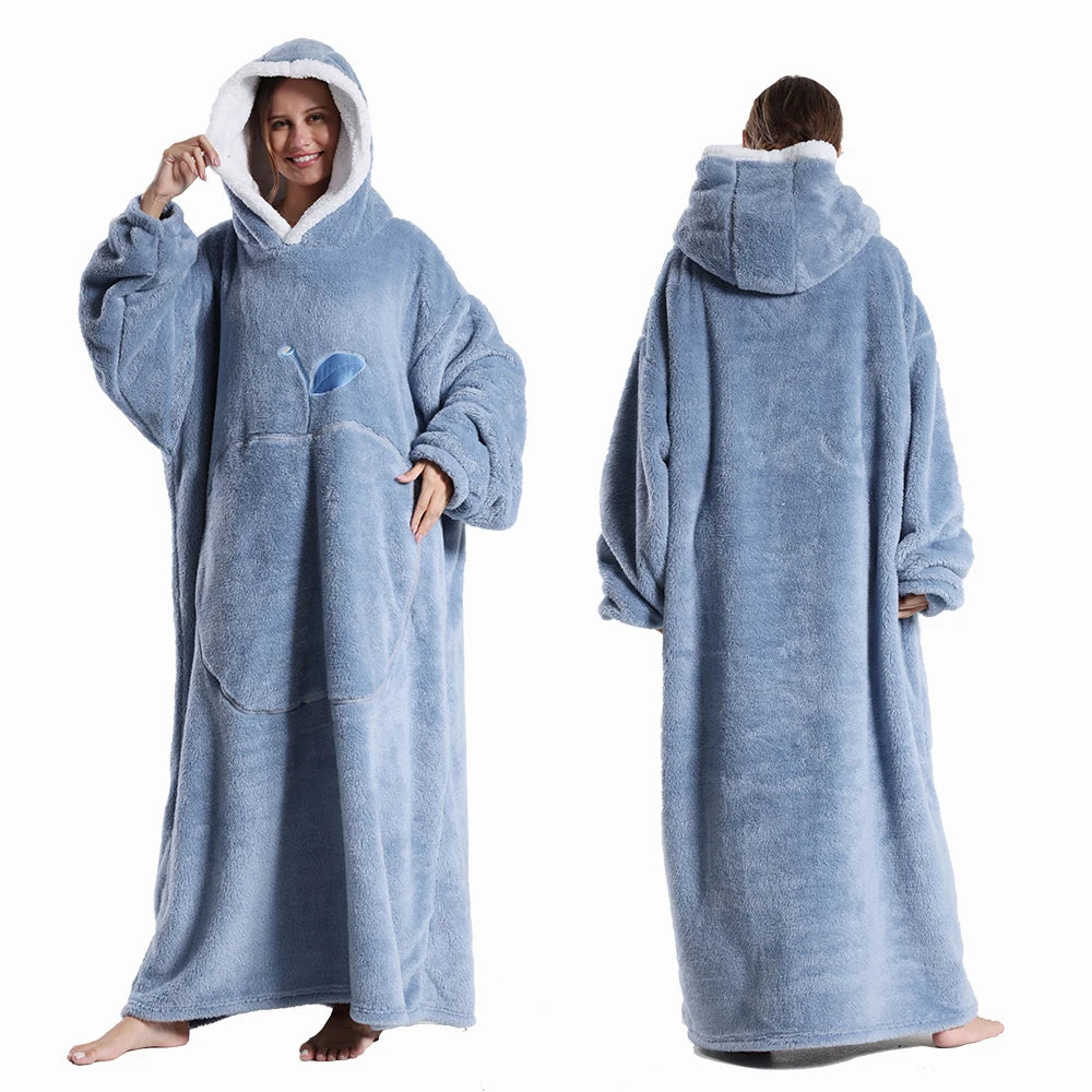 A person wearing a light blue ultra-soft plush fleece blanket hoodie with a hood and long sleeves.