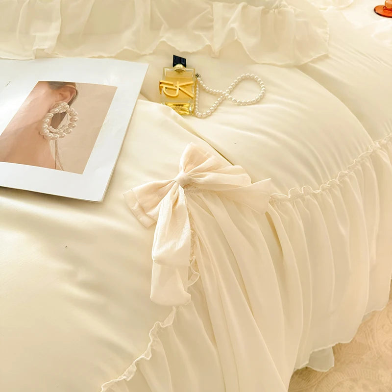 A light beige princess chiffon duvet cover set with a white pearl necklace and a framed photo.