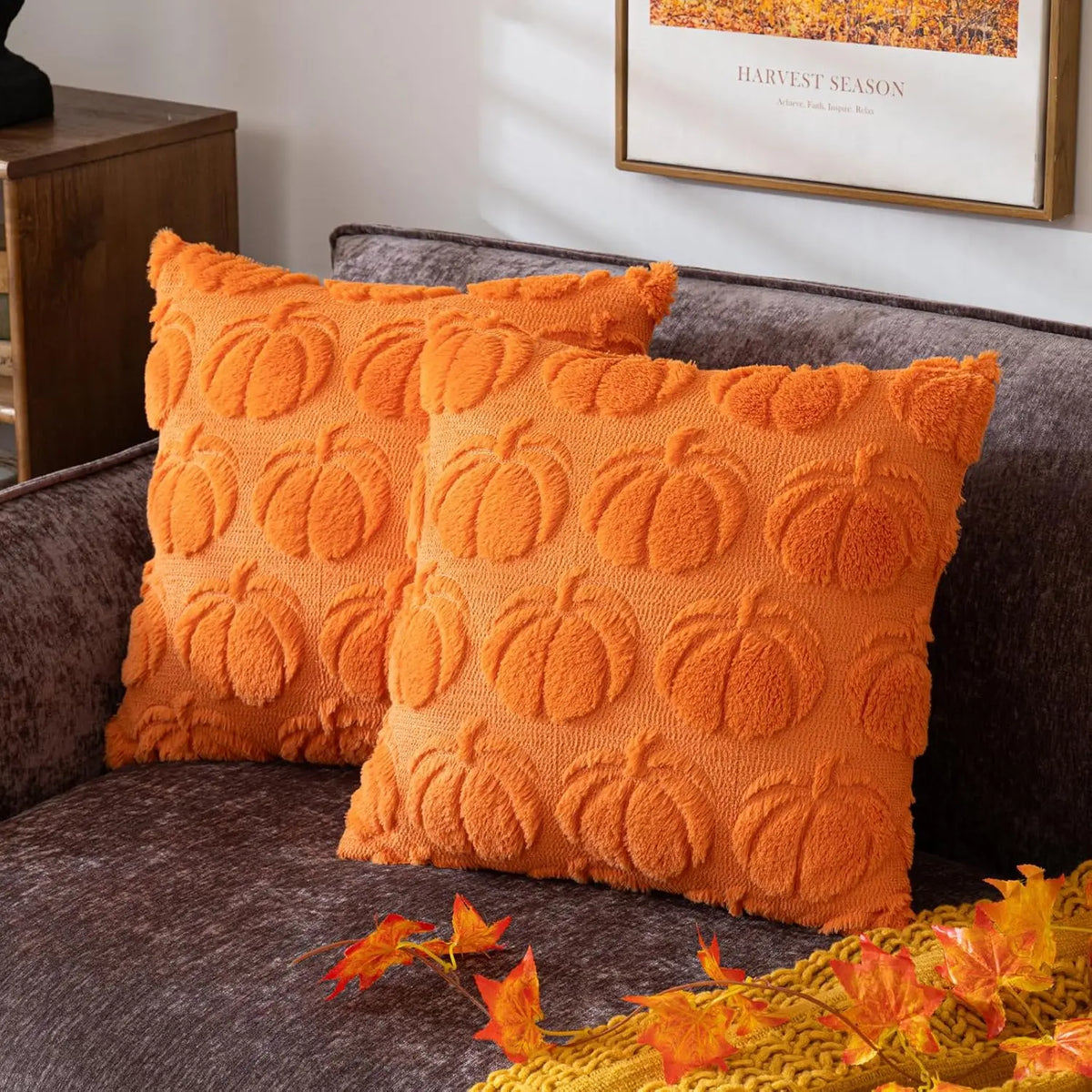 Two orange chenille throw pillows resting on a dark gray sofa.