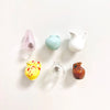 Five small ceramic landscape fridge magnets in pastel colors including pink, mint green, white, yellow, and brown.