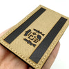 A tactical patch featuring the Spain flag design with a hook and loop backing, shown being held by a hand.