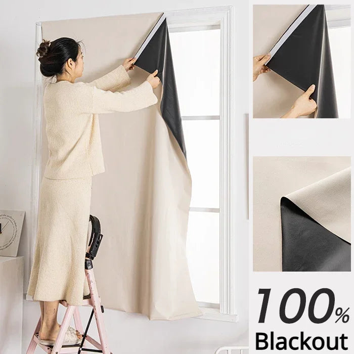A woman is installing blackout curtains on a window, showing the fabric and installation process.