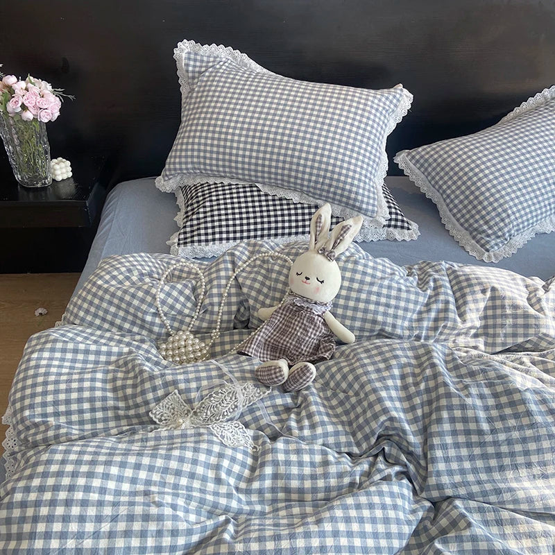 A plaid duvet cover and pillowcase set featuring blue and white gingham patterns with lace trim and a rabbit plush toy.