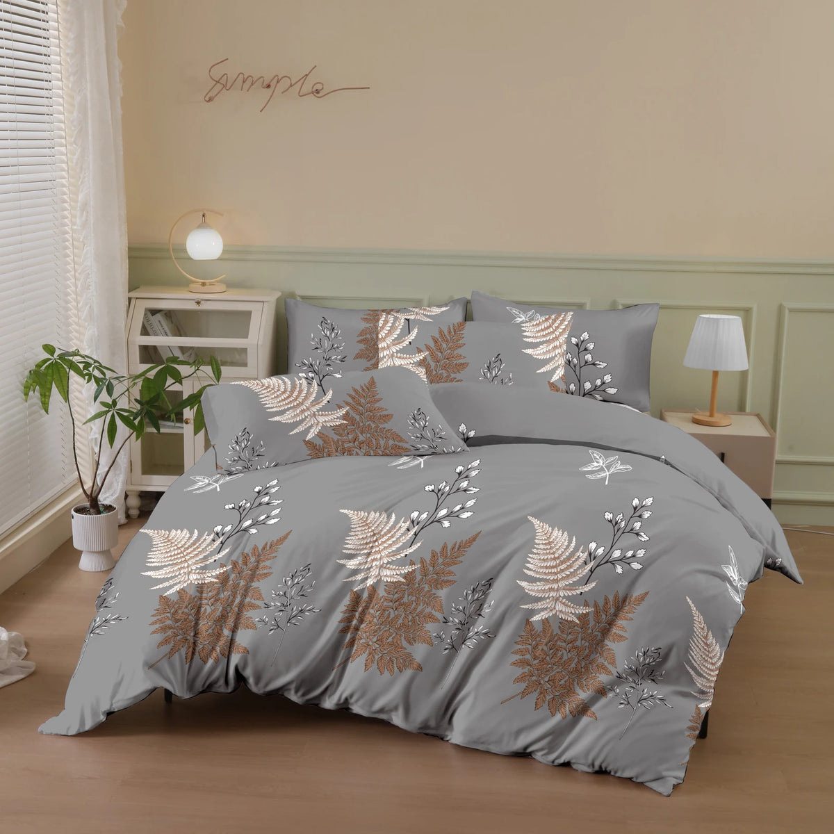 Gray duvet cover set featuring a botanical print with gold and silver foliage on a bed.