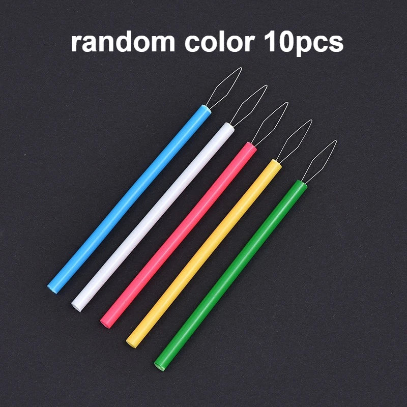 Ten random colored needle threaders with metal tips arranged diagonally on a dark background.