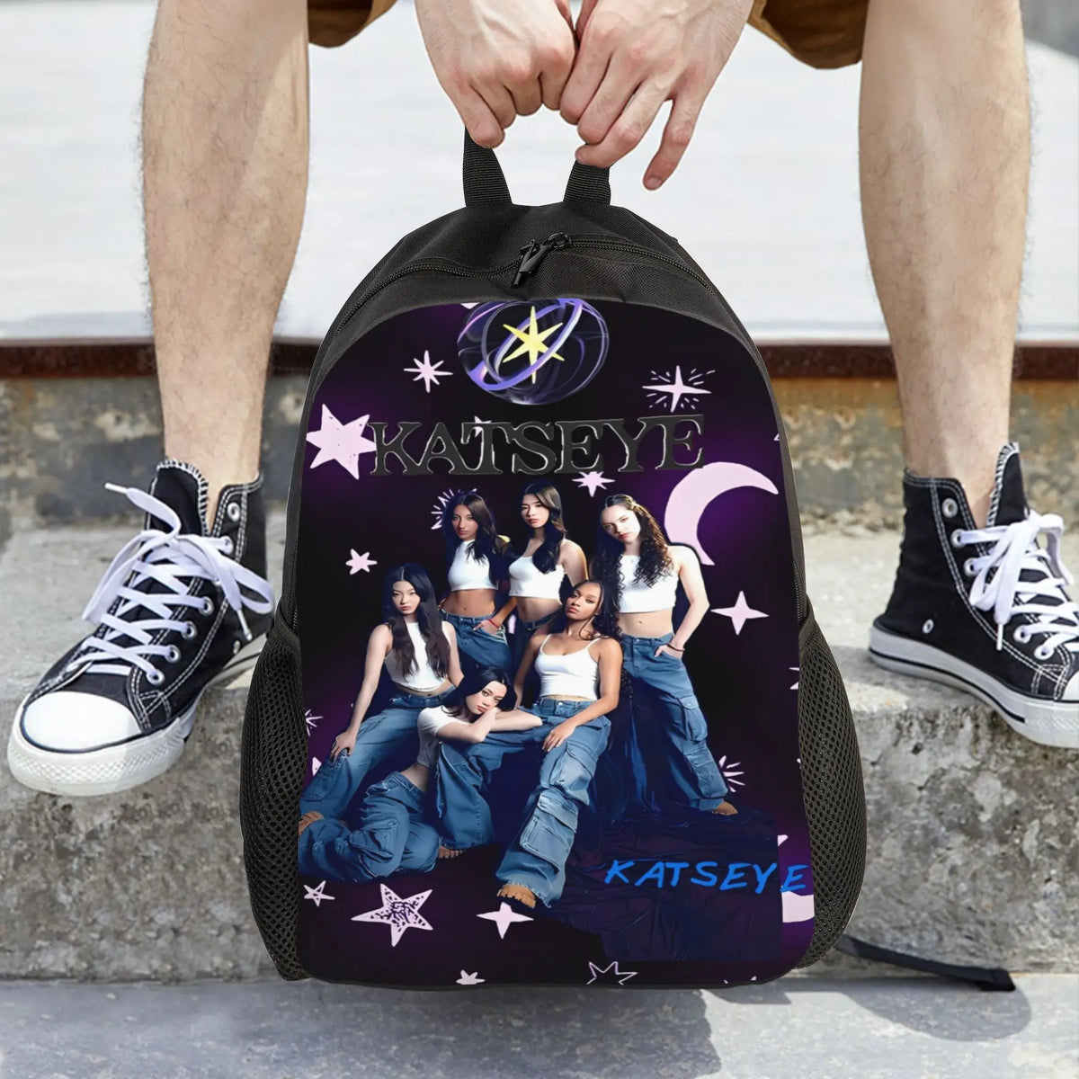 A purple canvas backpack featuring the name KATSEYE in white text and a crescent moon design.