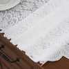 White embroidered lace table runner draped over a dark wood cabinet surface.