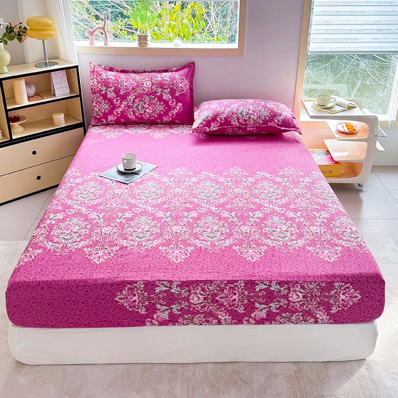 A vibrant pink floral print fitted bed sheet with matching pillows displayed on a bed.
