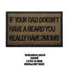 A black embroidered patch with text on a tan fabric background