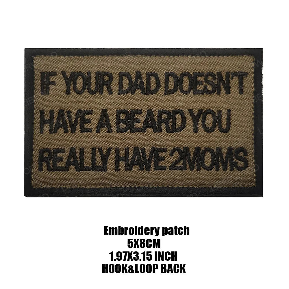 A black embroidered patch with text on a tan fabric background