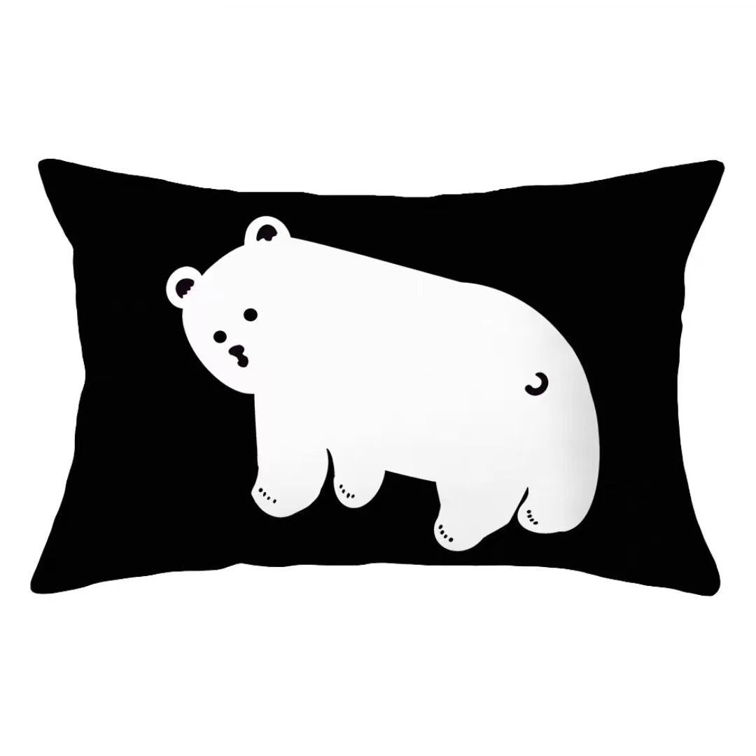 A white polar bear graphic printed on a black decorative pillow cover.