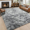 A plush gray long-pile area rug placed in a living room with a leather sofa and fireplace.