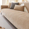 A beige waterproof anti-scratch sofa protection cover is draped over a light-colored sofa with gray and tan accent pillows.