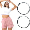 A woman models a pink crop top and matching shorts while demonstrating an adjustable crop tuck band product.