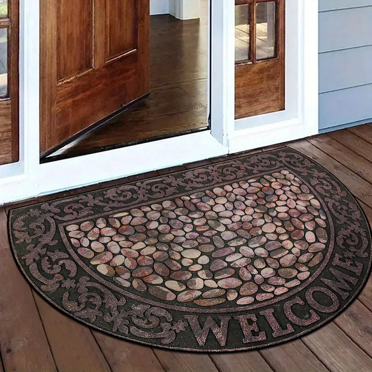 A semi-circular mosaic floor mat with a vintage floral print placed on a wooden floor near a glass door.
