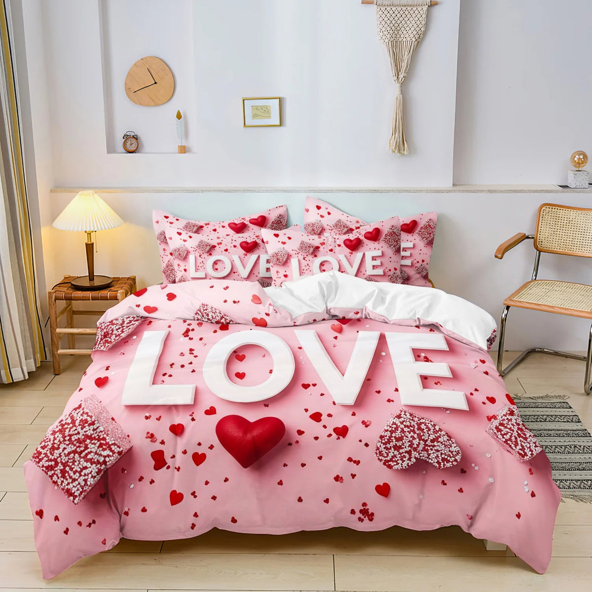Pink bedding set with red floral pattern and hearts displayed on a bed.