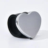 A silver heart-shaped magnetic pincushion with a black silicone band.