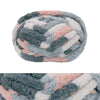 A ball of hand-knitted wool finger line scarf featuring gray and pink variegated fibers.