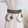A set of two vintage gold-toned curtain clips featuring intertwined rope designs, crescent moons, and stars.