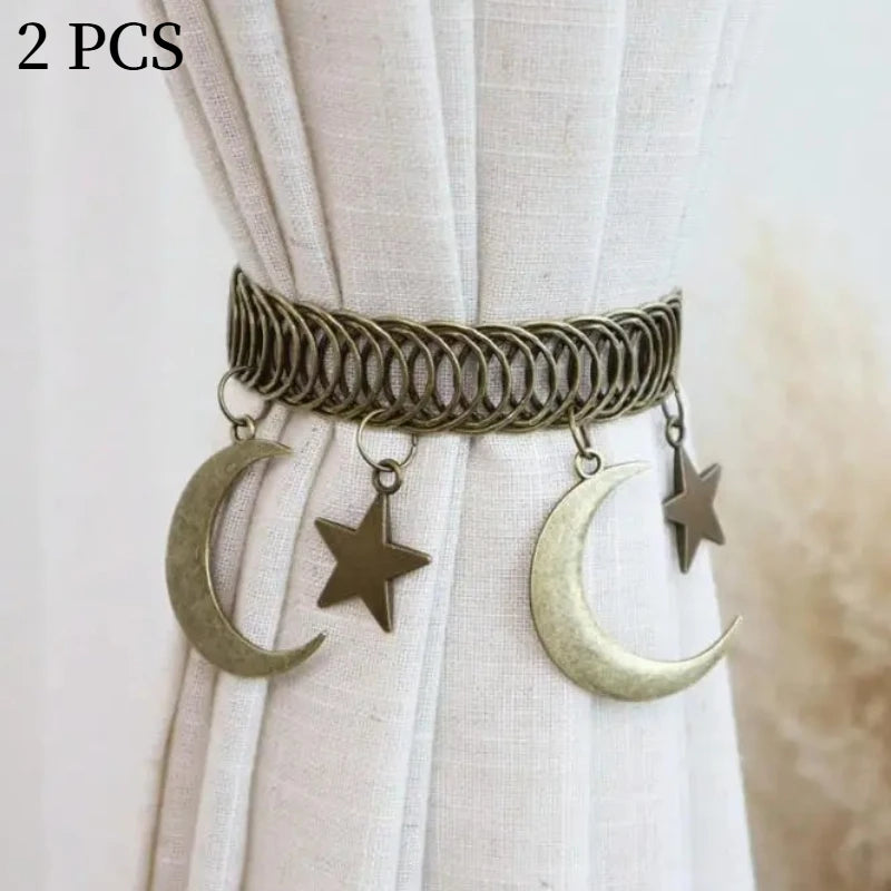 A set of two vintage gold-toned curtain clips featuring intertwined rope designs, crescent moons, and stars.