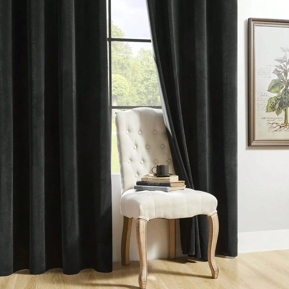 A light cream upholstered chair with gold legs is positioned in front of a dark gray curtain.