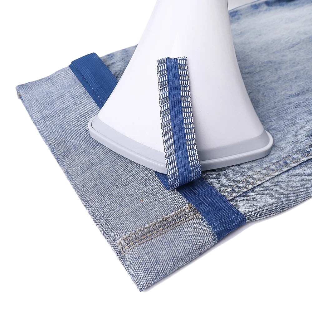 Blue self-adhesive hem tape applied to denim fabric for non-sew repair or shortening.