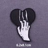Black embroidered patch featuring a hand and skull design for iron-on application