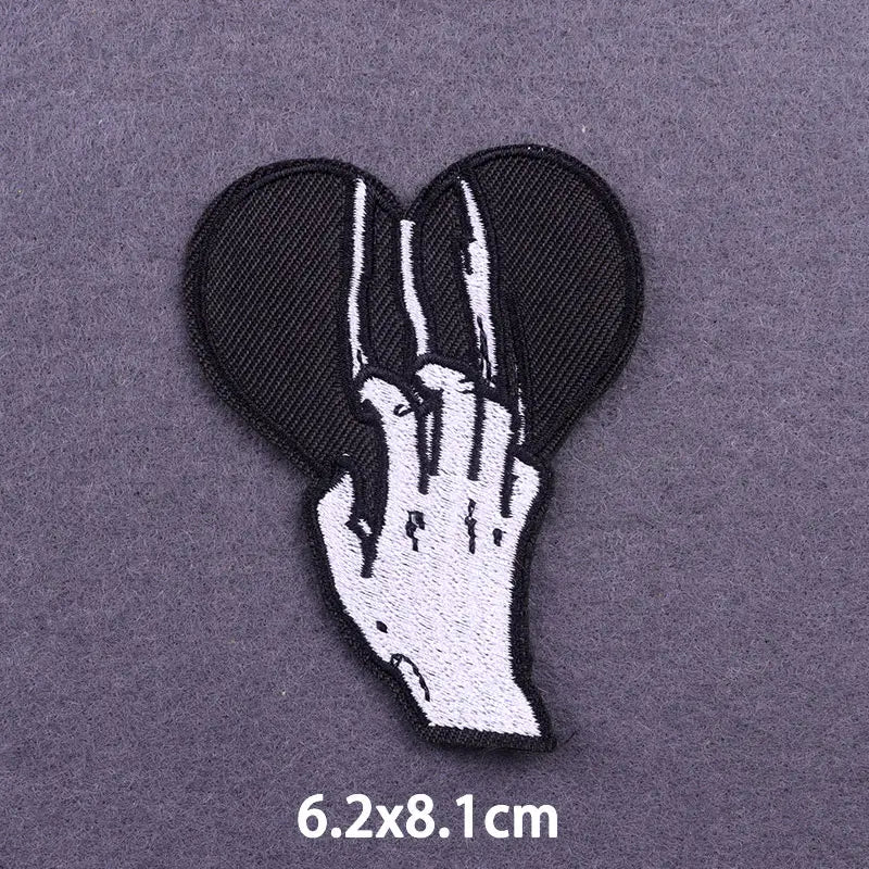 Black embroidered patch featuring a hand and skull design for iron-on application