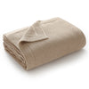 A beige knitted baby swaddle blanket rolled up and folded