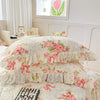 Two floral cotton pillow covers featuring pink roses and ribbons on a white background.