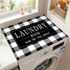 A laundry room featuring a white washing machine with a black and white plaid protection mat on top.