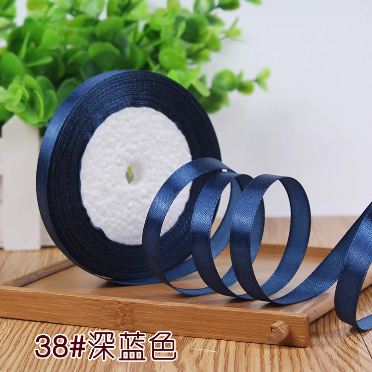 Roll of dark blue satin ribbon with a white center core