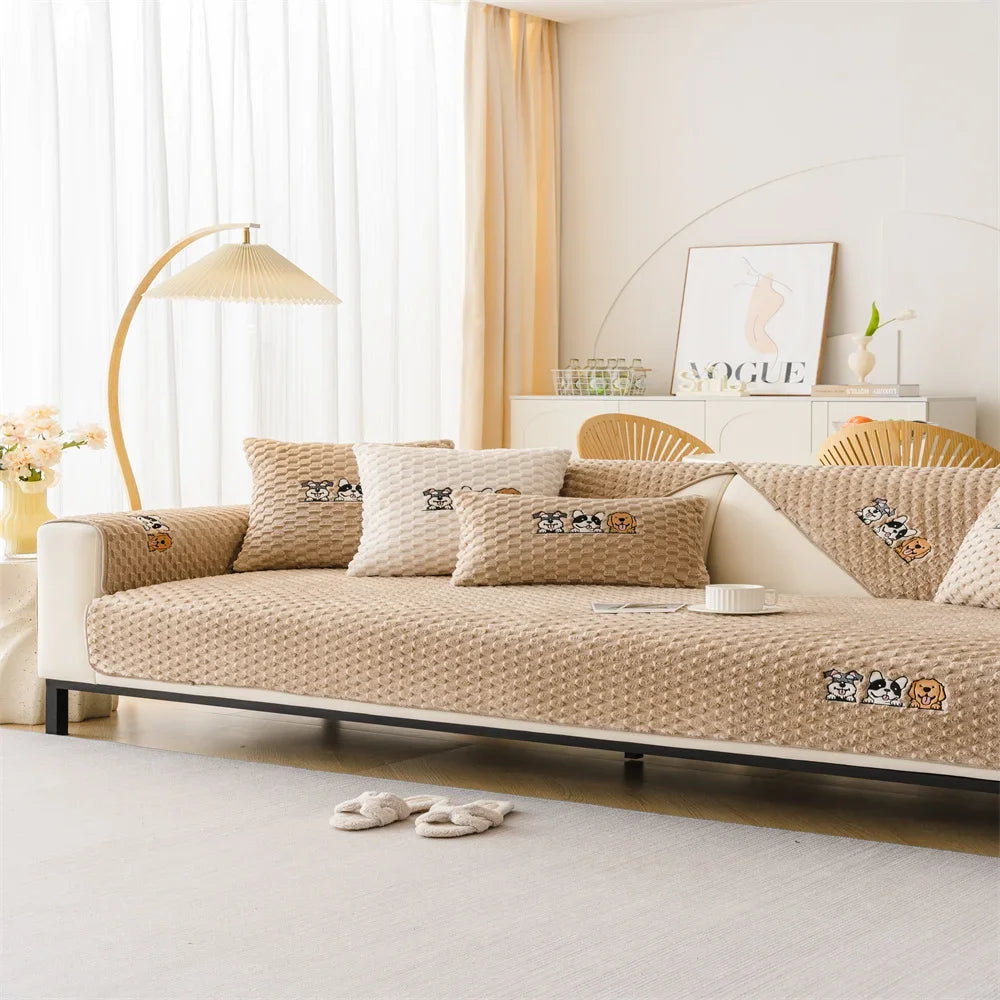 A beige non-slip plush sofa cover displayed on a modern sofa with light curtains and decorative pillows.