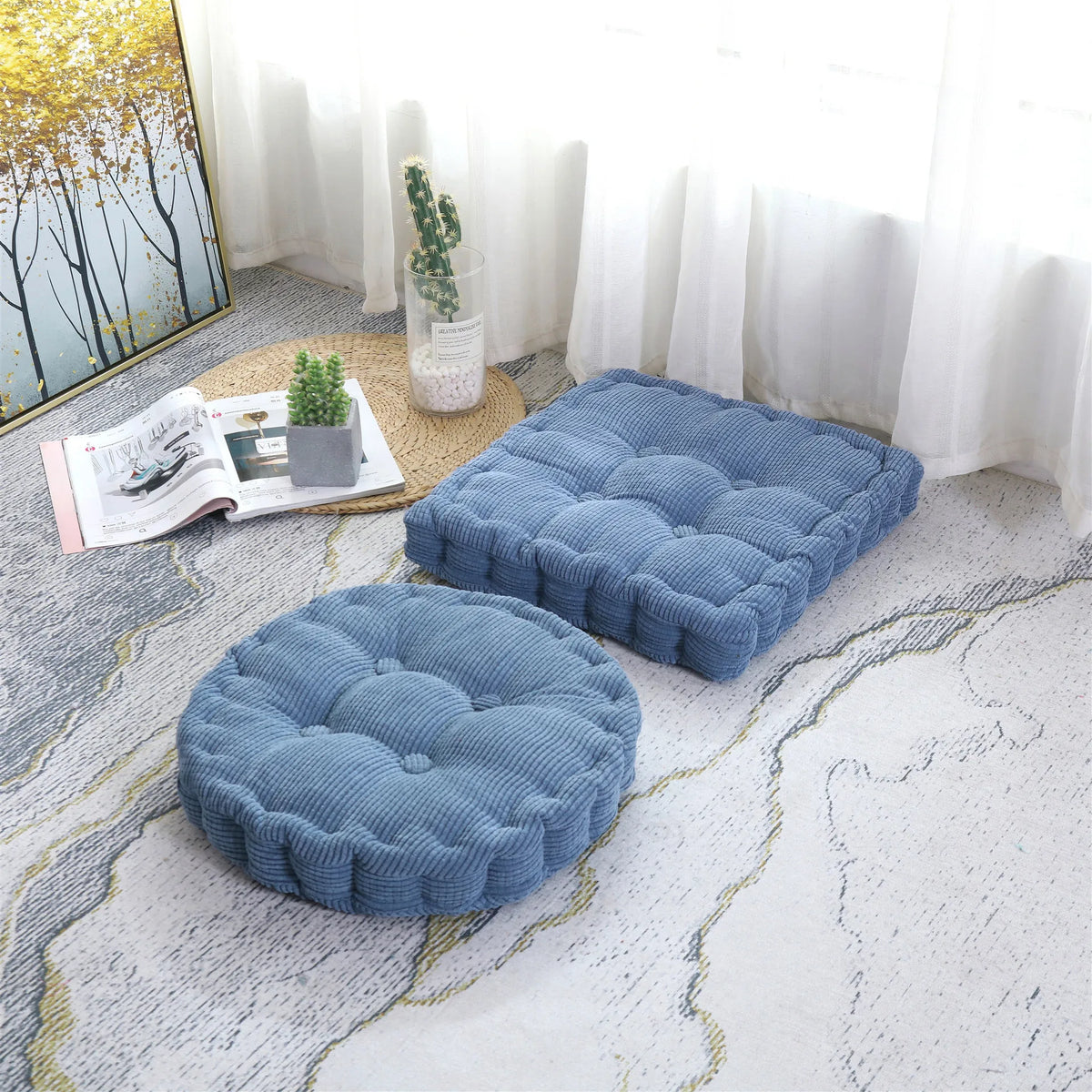 A navy blue tufted corduroy floor seat cushion resting on a light gray and white patterned floor.