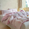 A pink and white striped quilt duvet set with matching pillowcases displayed on a bed.