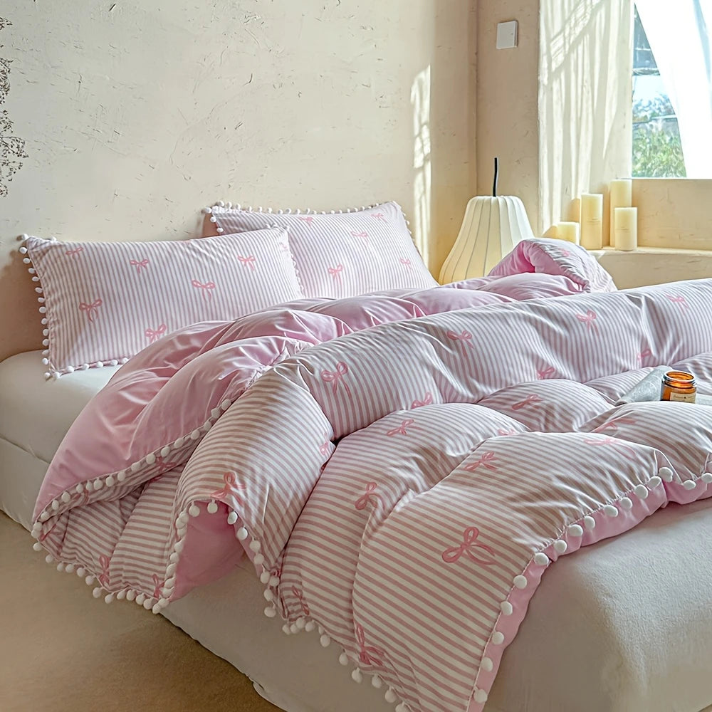 A pink and white striped quilt duvet set with matching pillowcases displayed on a bed.