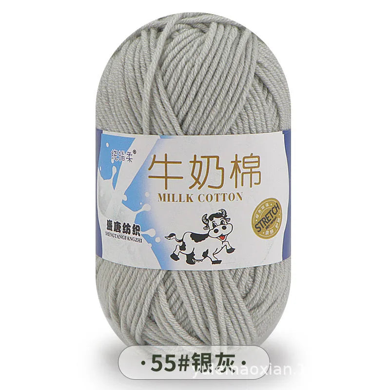 A ball of gray milk cotton yarn with a label in Chinese and English indicating the fiber type and stretch.