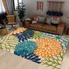 A vibrant outdoor area rug featuring a geometric pattern of teal, orange, and lime green botanical shapes.