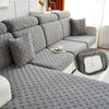 Gray jacquard plush sofa cushion covers arranged on a sofa and a matching floor cover.
